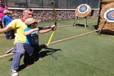 L'instructeur apprend au garçon à tirer un arc exactement vers la cible.